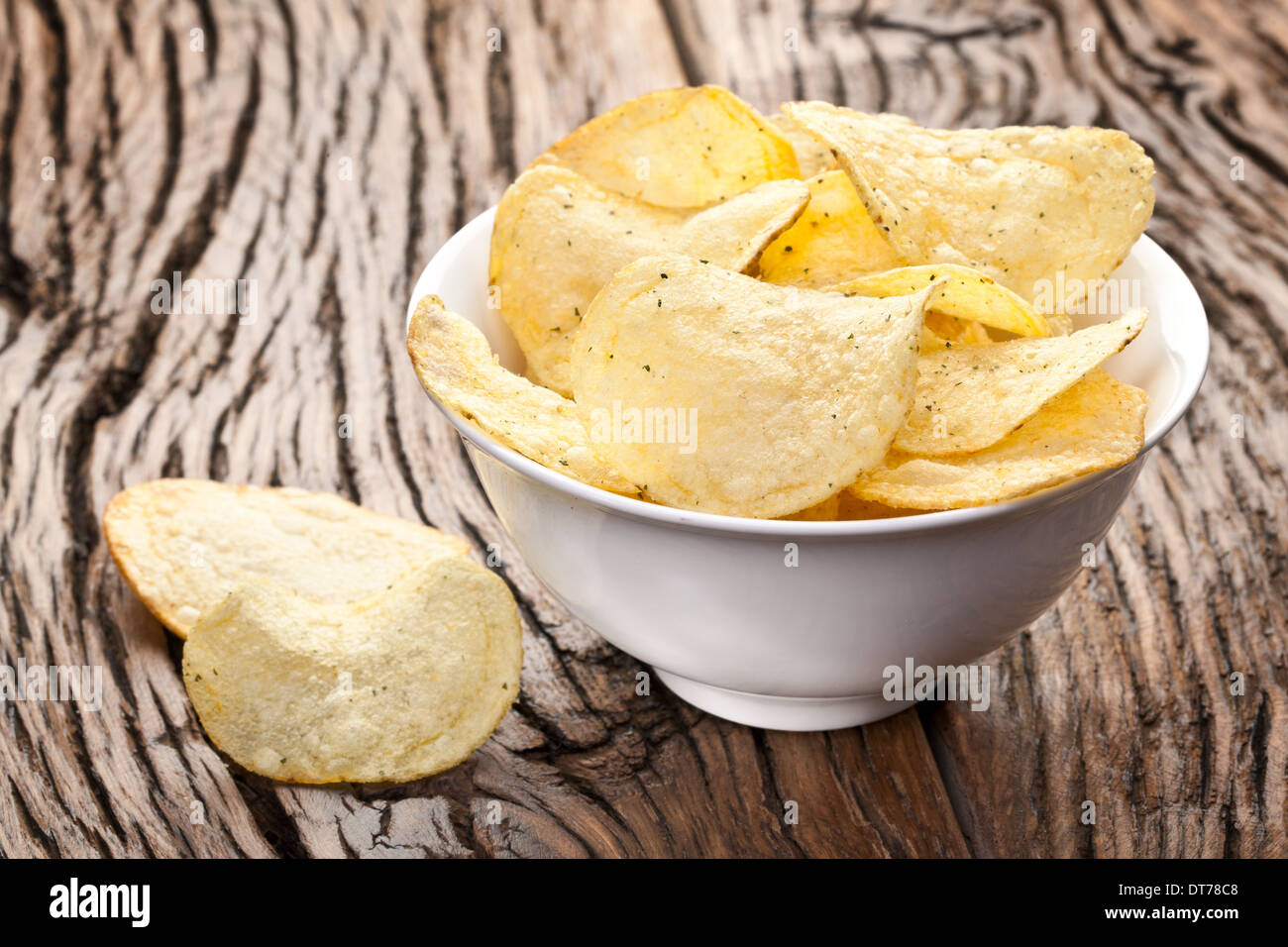 Patatine fritte in un recipiente su un tavolo di legno. Foto Stock