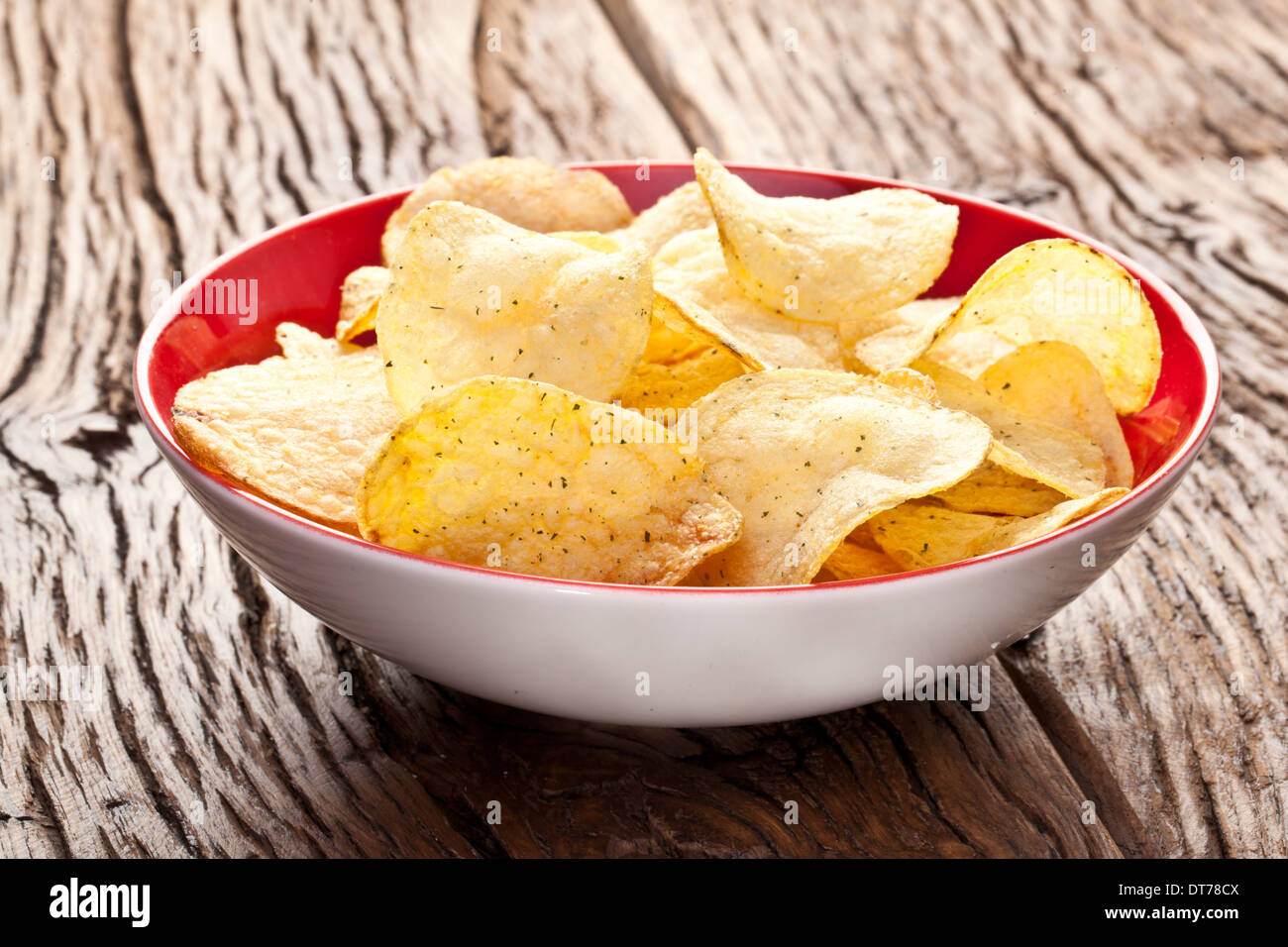 Patatine fritte in un recipiente su un tavolo di legno. Foto Stock