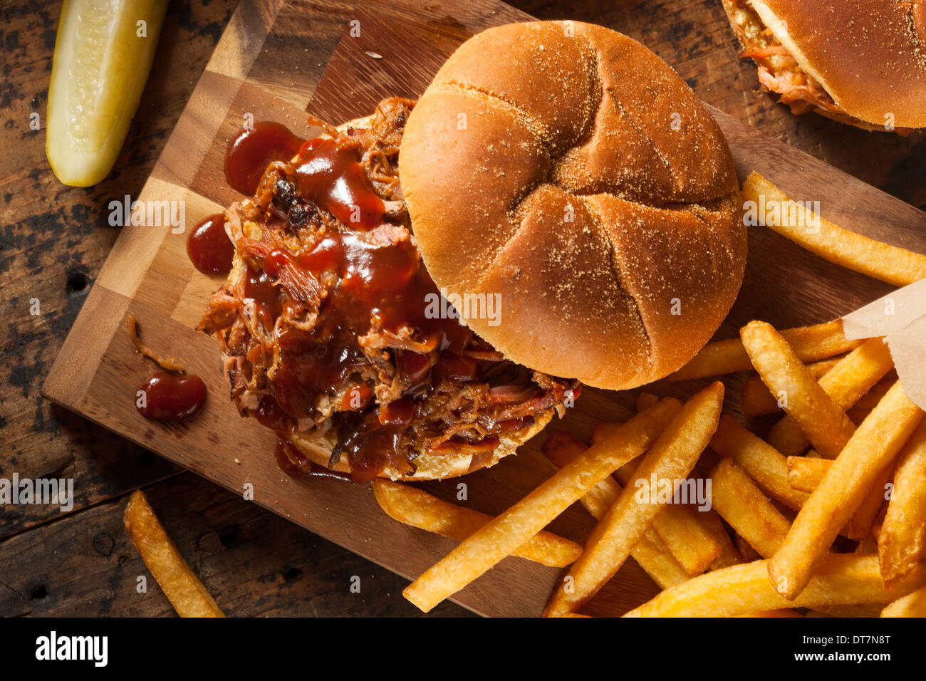 Barbeque tirato Sandwich di maiale con salsa barbecue e patatine fritte Foto Stock