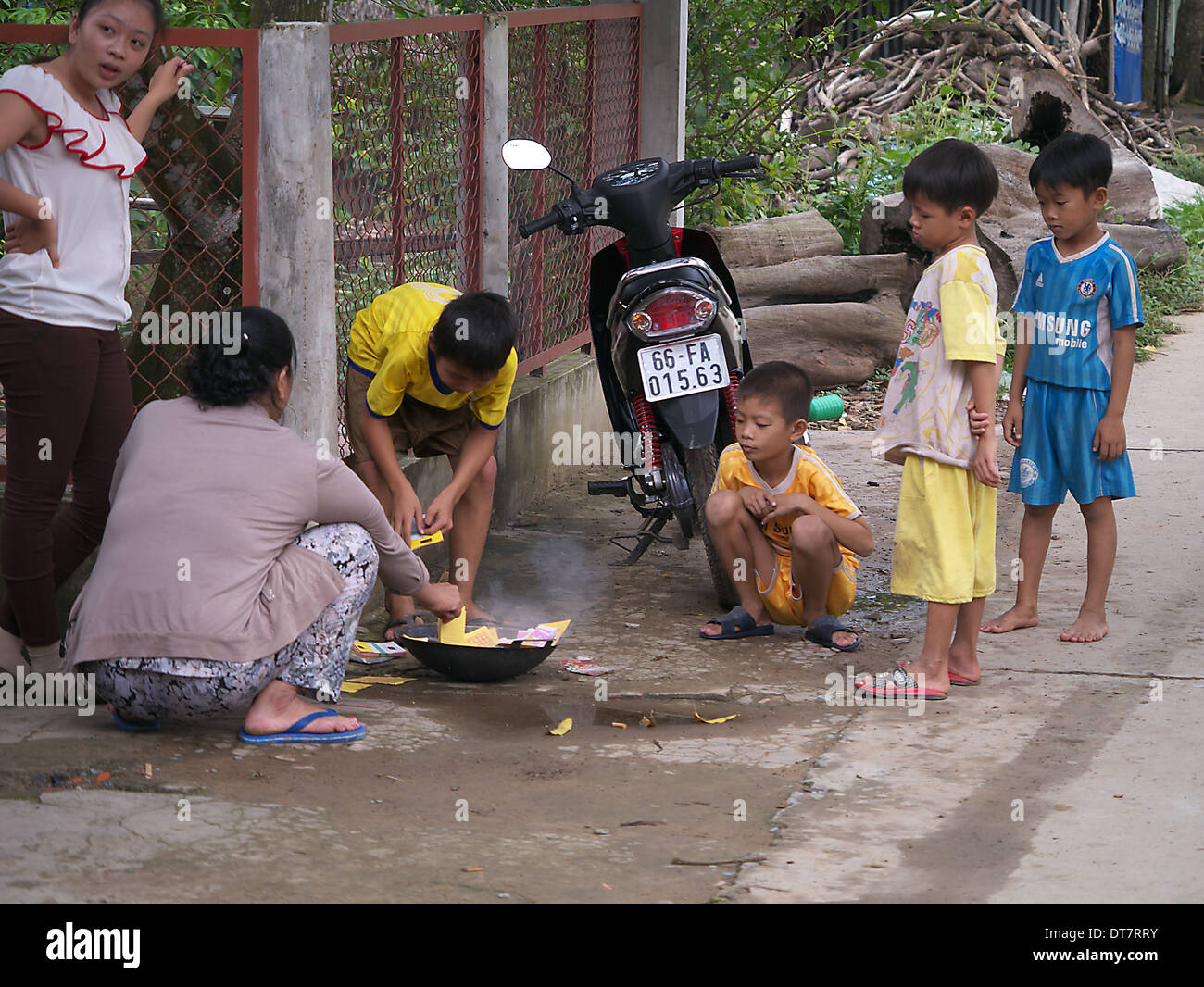Famiglia bruciando denaro falso in strada per i loro antenati Cambogia Foto Stock