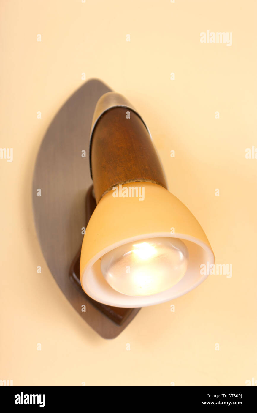Un legno e metallo luce da parete iluminates resdidential una parete interna. Foto Stock