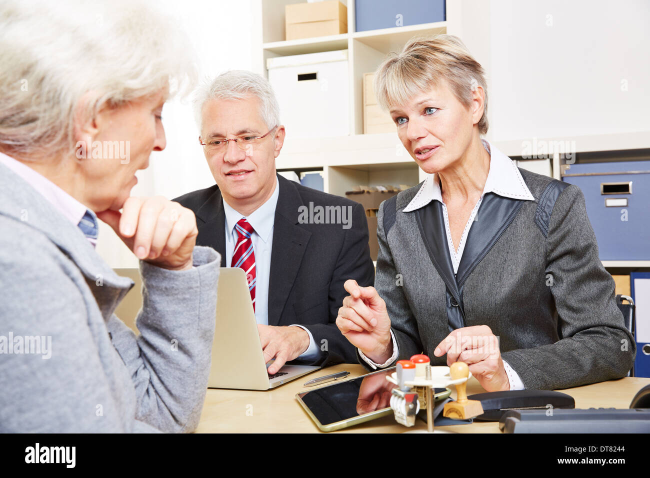 Anziana donna senior presso la comunicazione su questioni di carattere finanziario in una banca Foto Stock