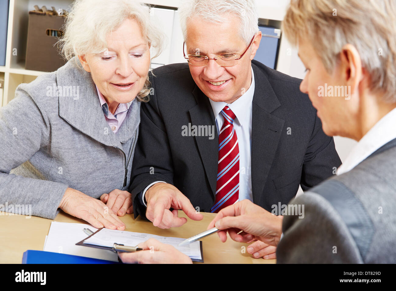 Coppia senior iscritto firma sotto contratto dopo la consulenza finanziaria Foto Stock