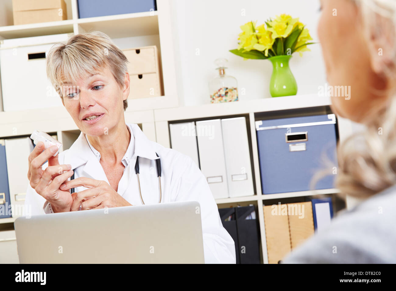 Medico parlando di farmaco al paziente anziano nel suo ufficio Foto Stock