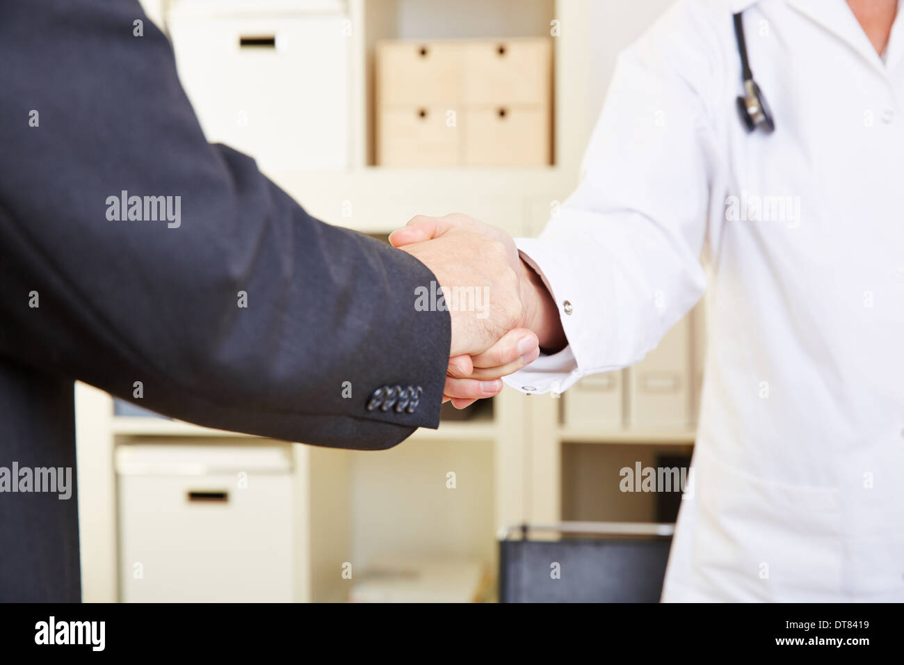 Stretta di mano tra il paziente e il medico in un ufficio Foto Stock