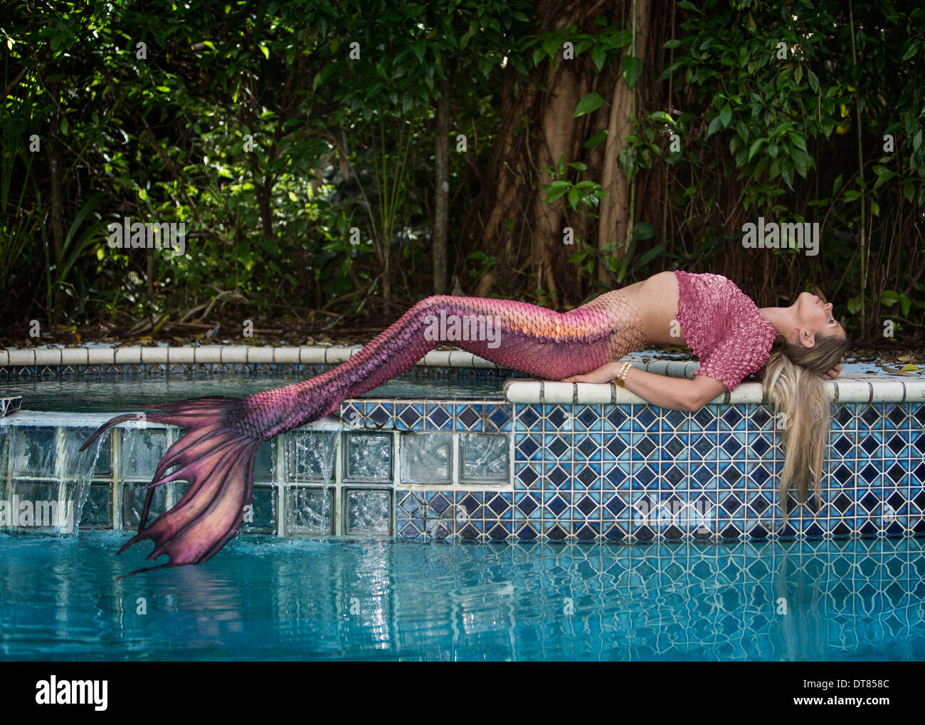 Mermaid posa da una giungla piscina, in Florida Foto Stock