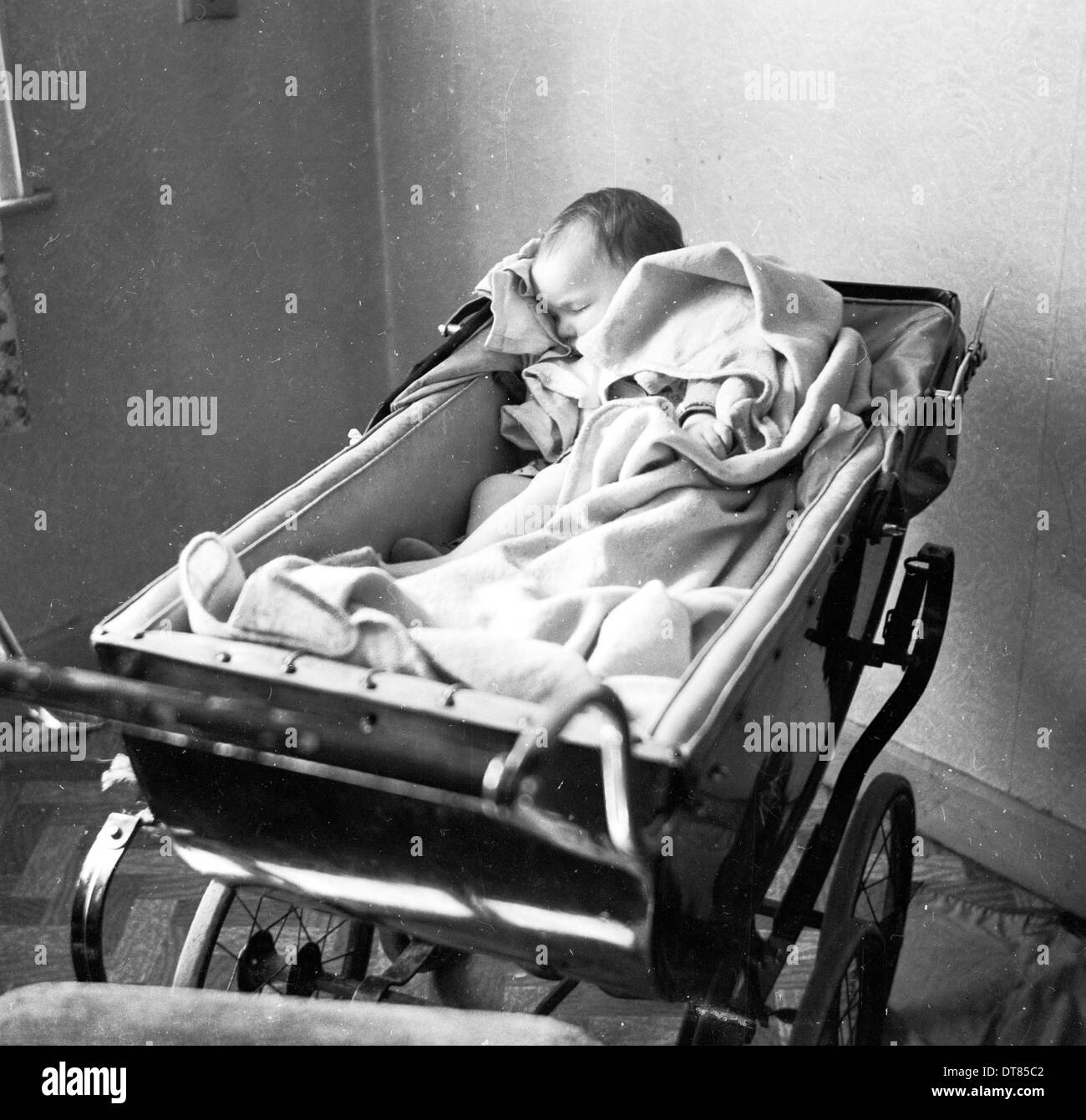 Foto storiche da anni cinquanta che mostra un bambino nella sua PRAM. Foto Stock