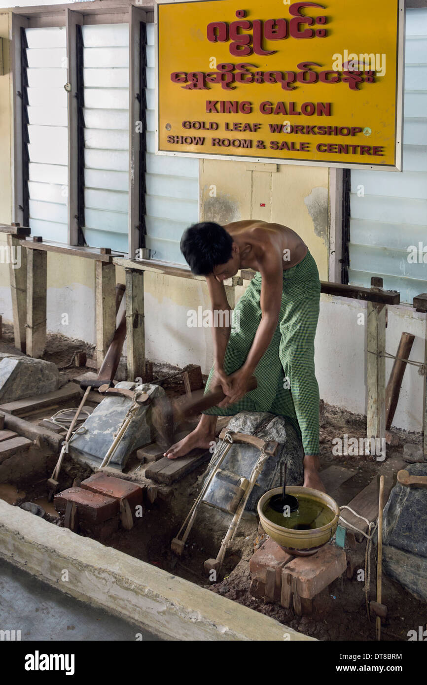 Lavoratore oro pounding oro avvolto in carta pergamena in foglia oro, Mandalay Myamar Foto Stock
