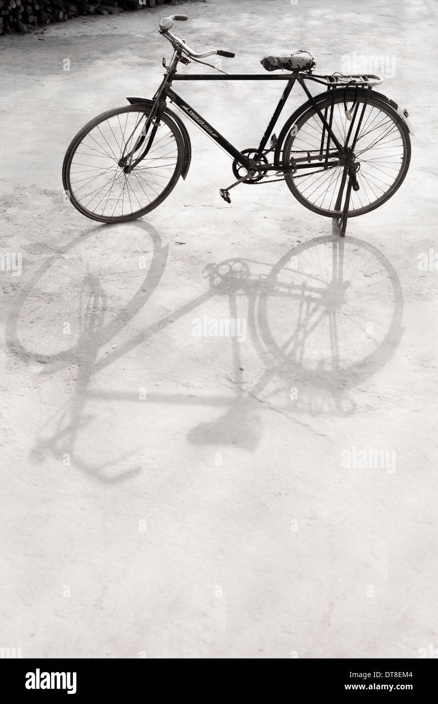 Una bicicletta trovata nel garage, shadow, riflessione, in bianco e nero Foto Stock