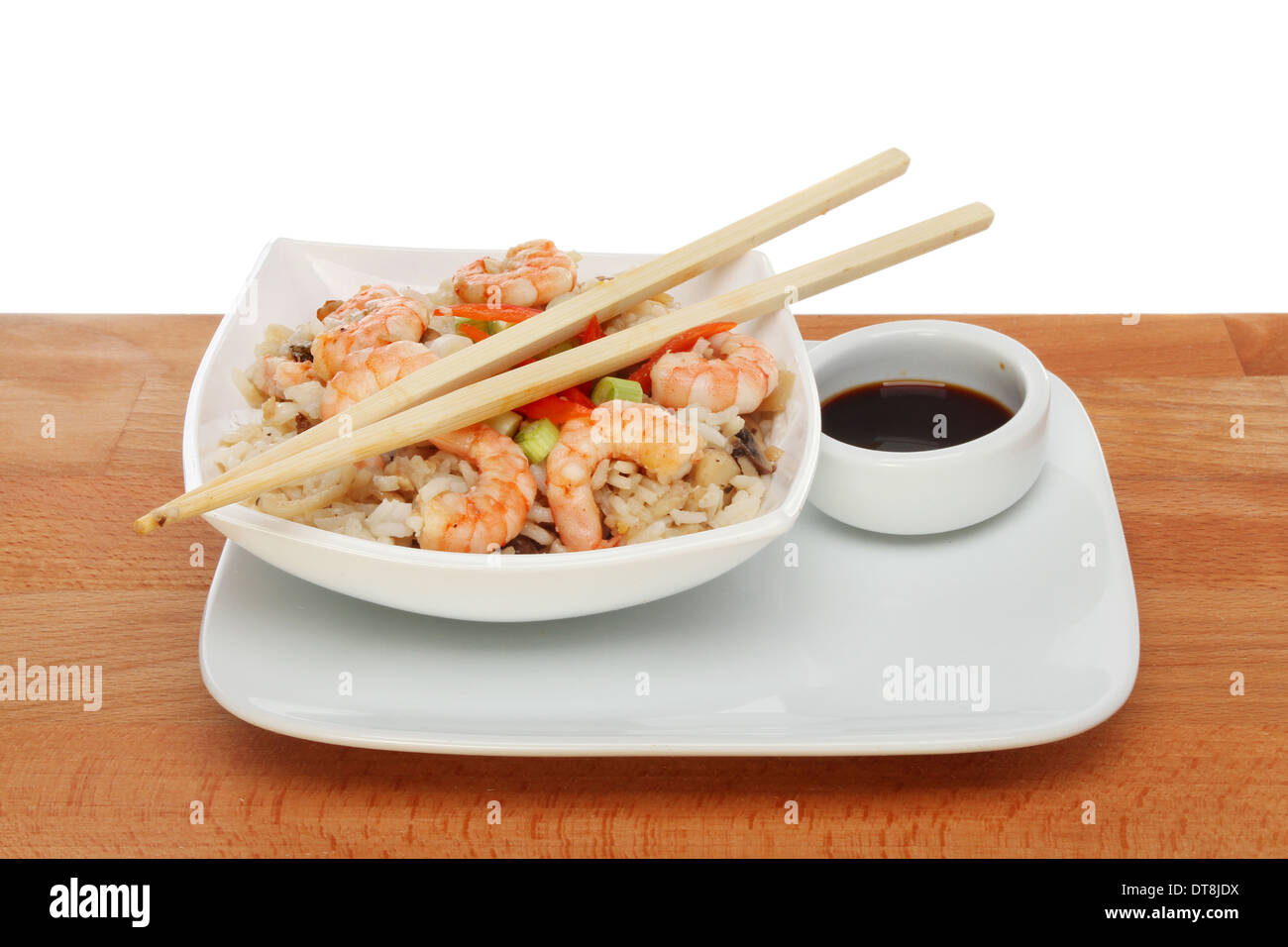 Pasto asiatico con bacchette e la salsa di soia, su di un tavolo di legno contro uno sfondo bianco Foto Stock