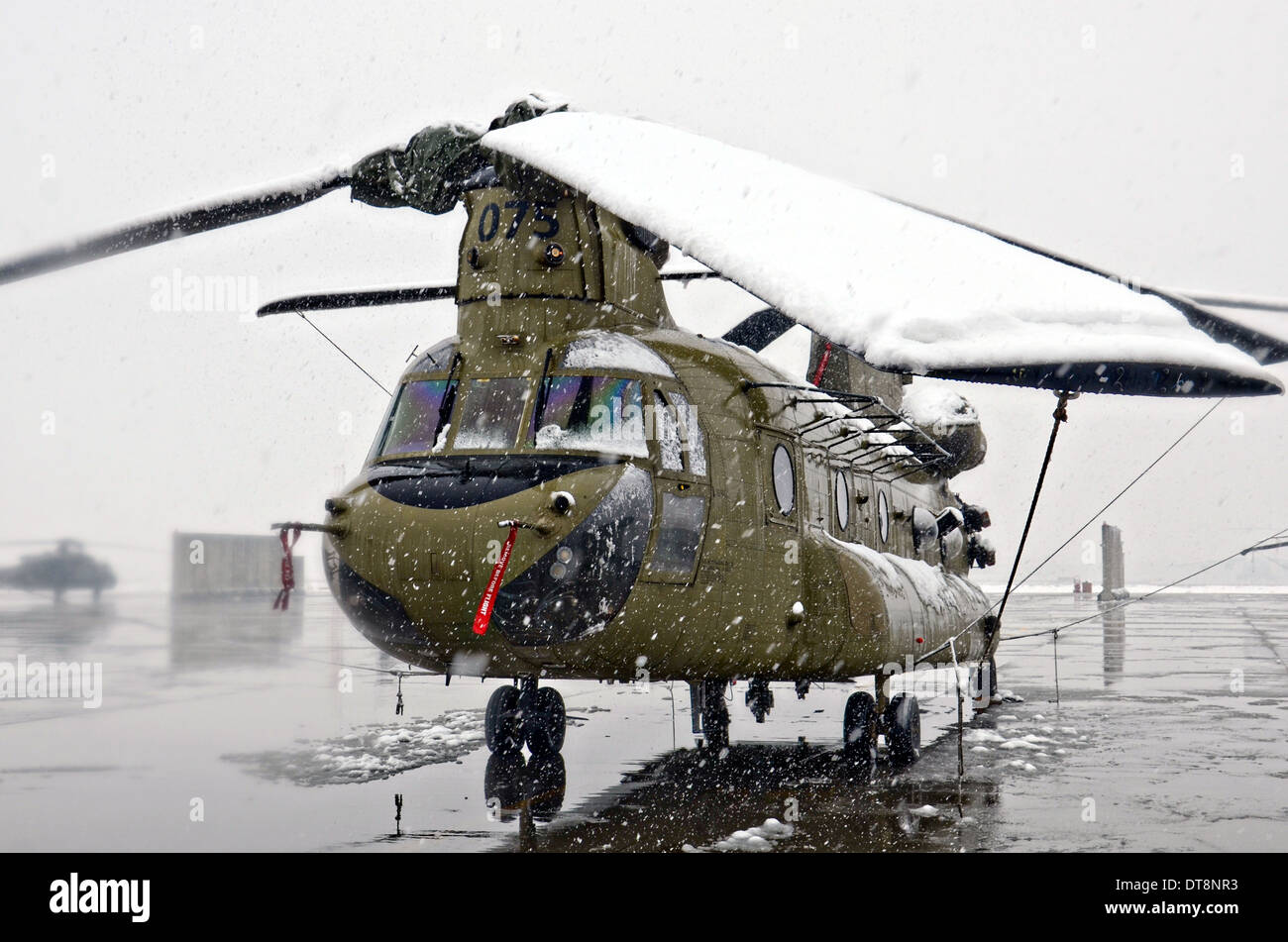 La neve copre un esercito USA CH-47 elicottero Chinook durante una tempesta di neve in inverno Febbraio 6, 2014 a Bagram Air Field, Afghanistan. Foto Stock