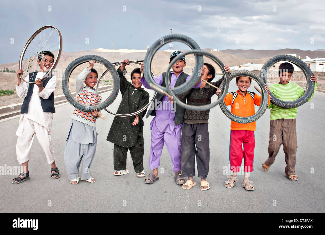 Giovani ragazzi afghani mostrare i loro pneumatici di biciclette utilizzate come un giocattolo in campagna Giugno 23, 2012 a Bamyan, Afghanistan. Foto Stock