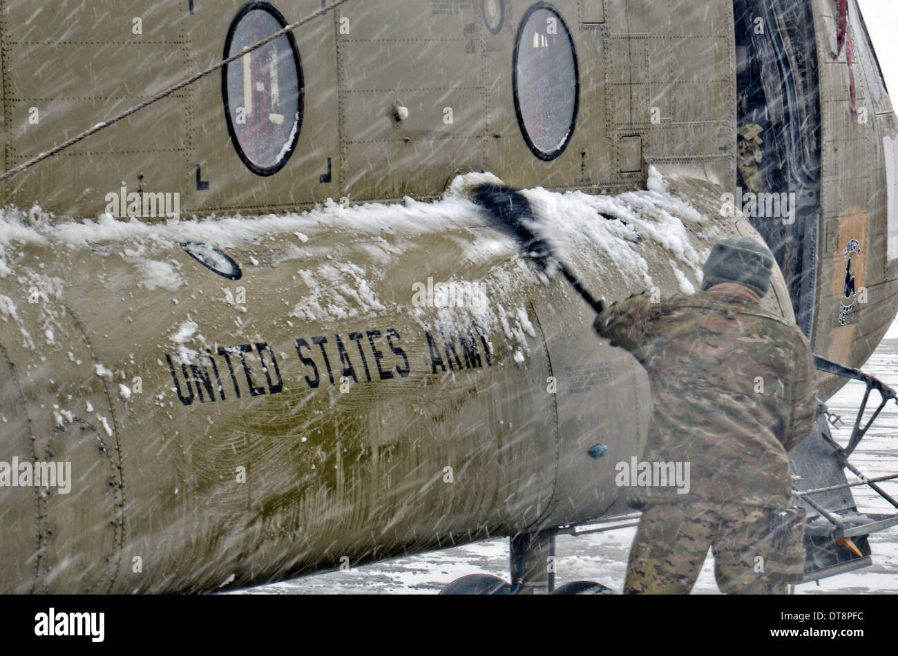 I soldati USA spazzare la neve fuori un CH-47 elicottero Chinook durante una tempesta di neve in inverno Febbraio 6, 2014 a Bagram Air Field, Afghanistan. Foto Stock
