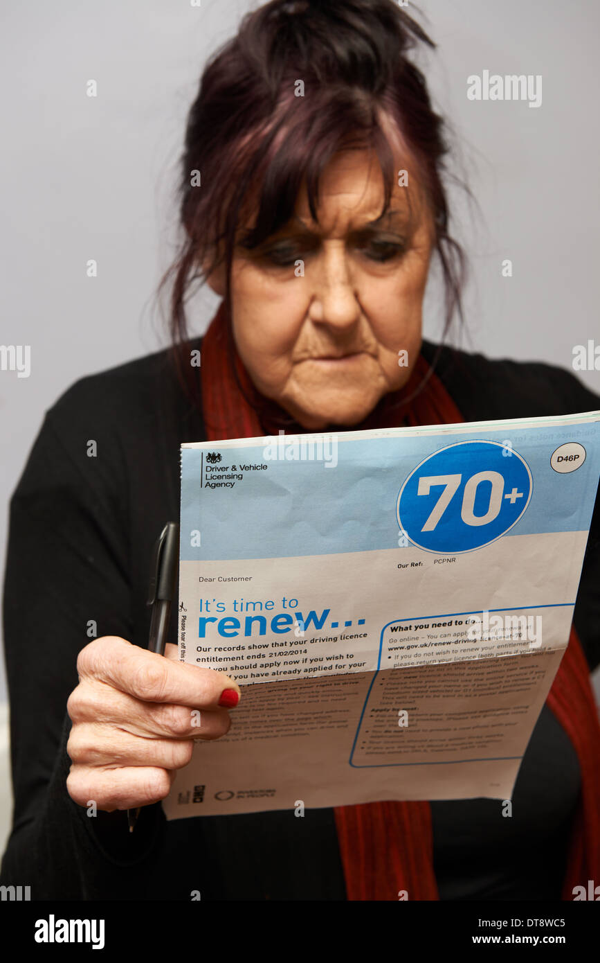 Oltre 70 anni di vecchia donna il rinnovo della patente di guida Foto Stock