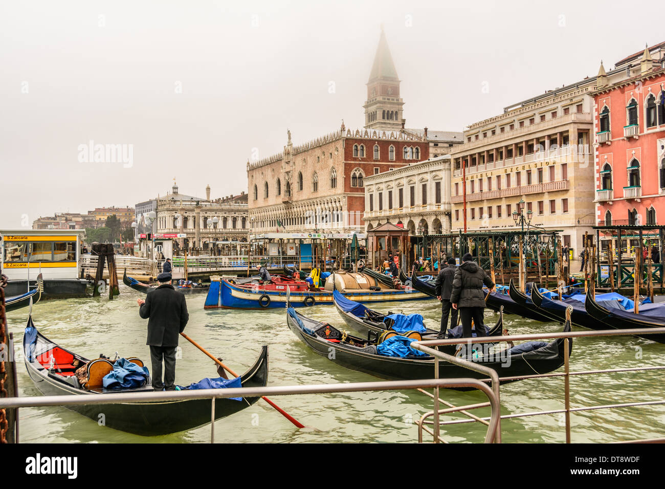 Inverno a Venezia, Italia. Venetian gondole e gondolieri sovrastante la Mole, Palazzo Ducale, Libreria, fermata dei vaporetti di S. Zaccaria, Hotel Danieli Excelsior. Foto Stock