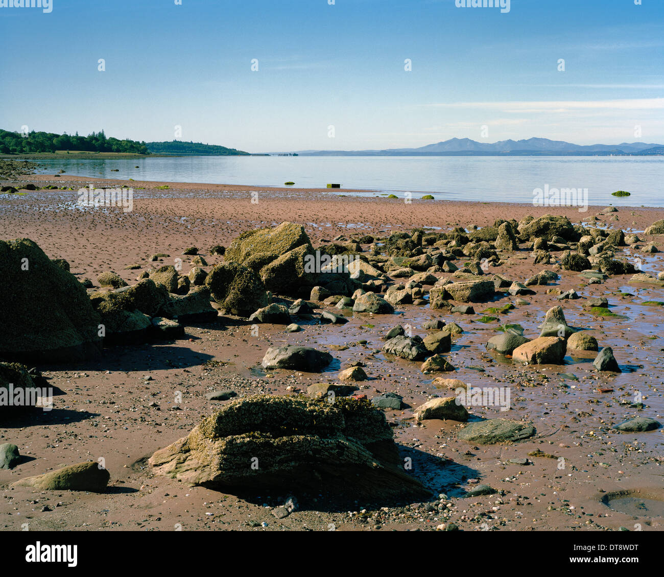 Le rocce su Lunderstone Bay beach nel Firth of Clyde guardando verso l'isola di Arran Foto Stock