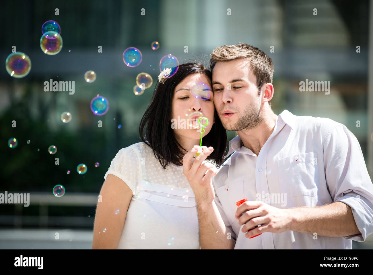 Coppia giovane hanno un grande tempo insieme con bolla di soffiante - fuori in strada Foto Stock