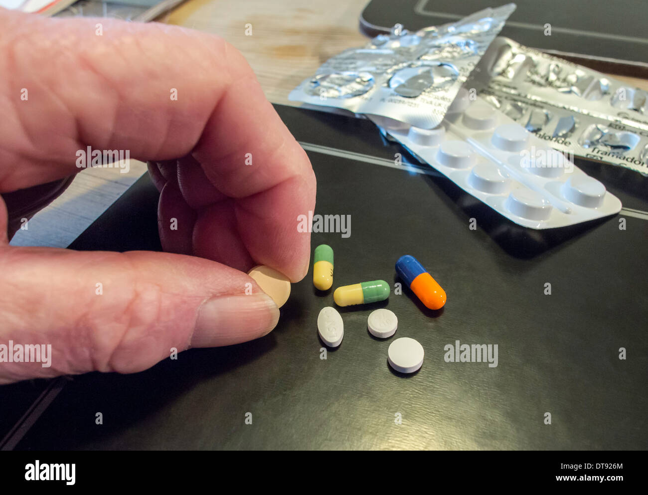 Anziani mano d'uomo con selezione di pillole, compresse e capsule. Dose giornaliera di farmaco. Foto Stock