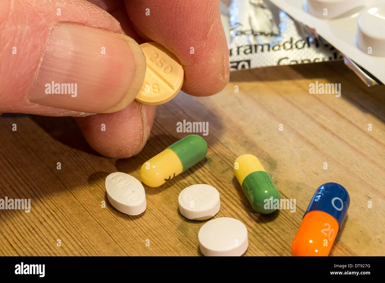 Anziani mano d'uomo con selezione di pillole, compresse e capsule. Dose giornaliera di farmaco. Foto Stock