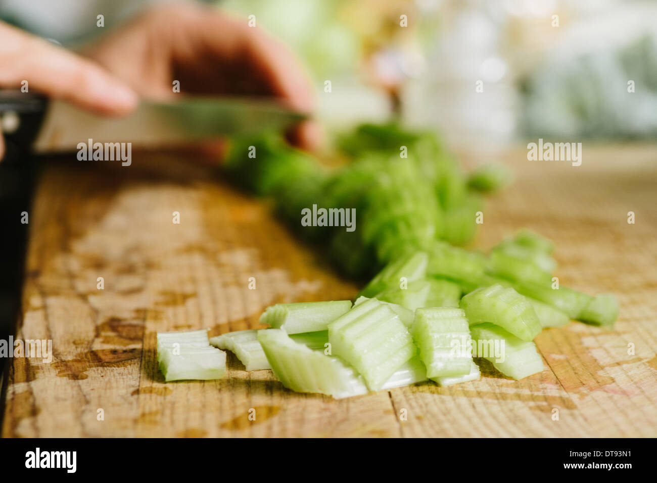 Essendo di sedano tritato o tagliato su un tagliere Foto Stock