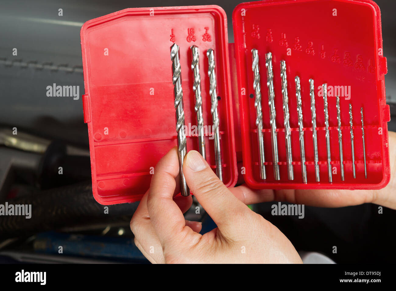 Foto orizzontale di femmine della mano azienda punta da trapano con toolbox in background Foto Stock
