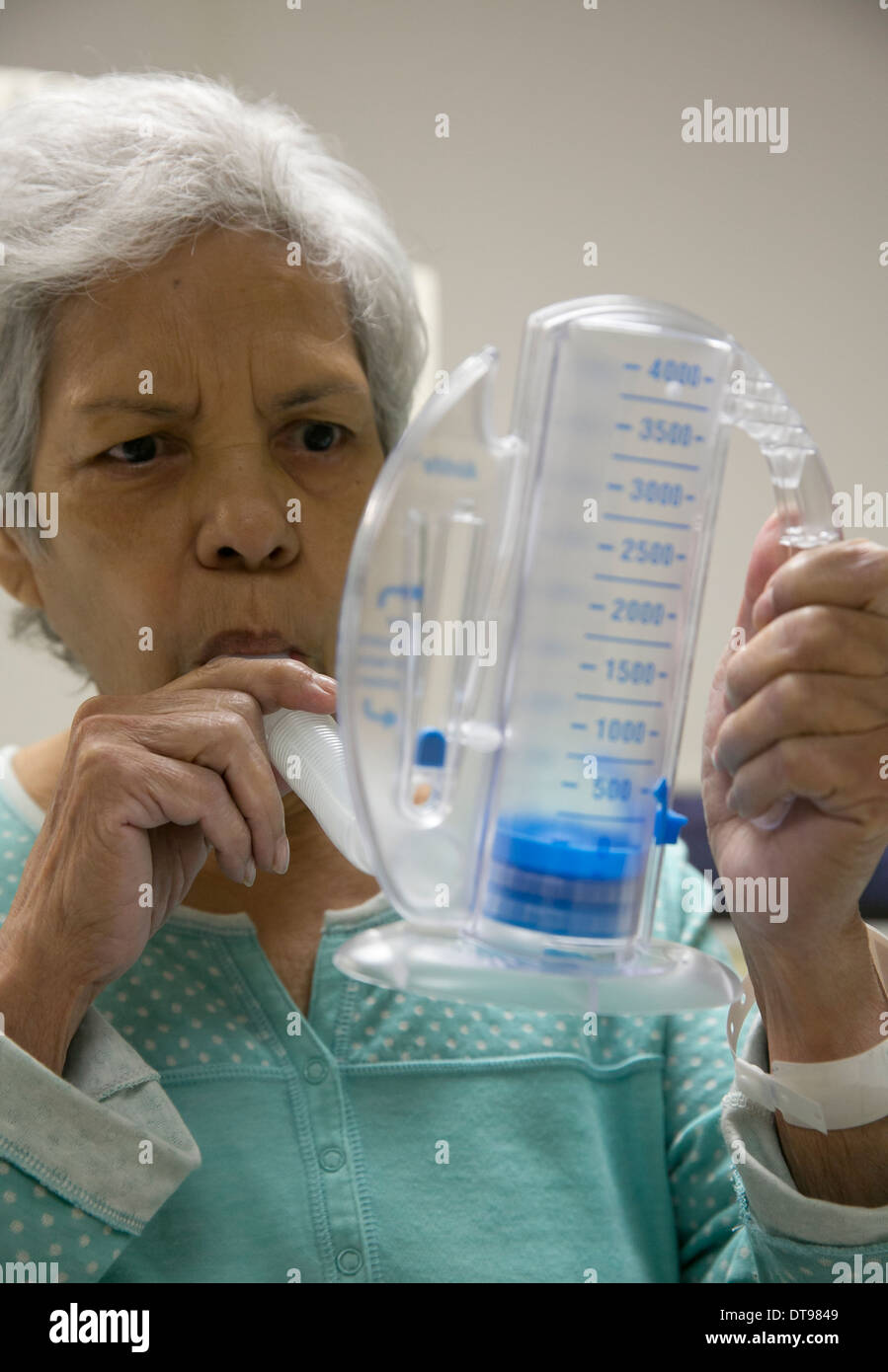 75 enne ispanico senior citizen utilizza un medico di esercizio di respirazione apparecchio mentre in un ospedale di riabilitazione in Texas. Foto Stock