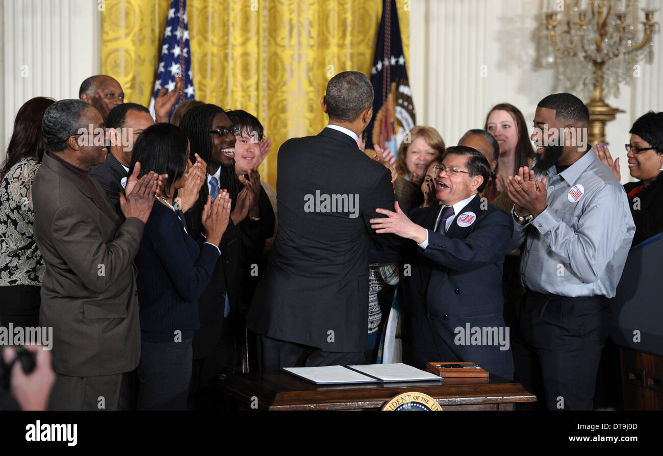 Washington, Stati Uniti d'America. 12 feb 2014. Stati Uniti Il presidente Barack Obama è accolto da lavoratori dopo la firma di un ordine esecutivo per aumentare il salario minimo per contratto federale lavoratori nella Sala Est della Casa Bianca a Washington DC, Stati Uniti, Feb 12, 2014. La mossa, prima annunciato durante il discorso sullo stato dell'Unione, farà aumentare il salario minimo per gli appaltatori federale a 10.10 dollari all'ora da il tasso attuale di 7,25 dollari. Credito: Yin Bogu/Xinhua/Alamy Live News Foto Stock