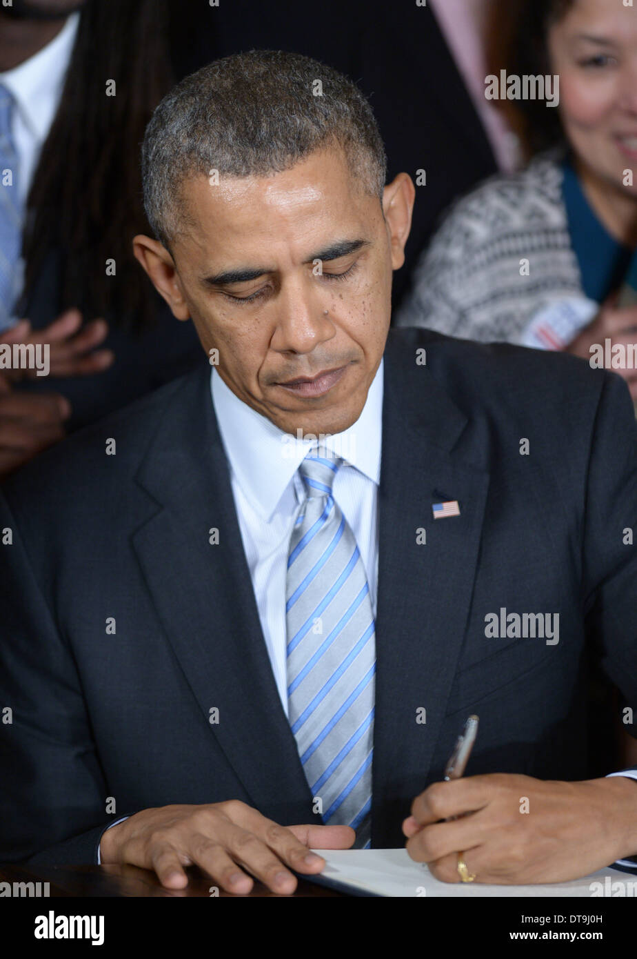 Washington, Stati Uniti d'America. 12 feb 2014. Stati Uniti Il presidente Barack Obama firma un ordine esecutivo per aumentare il salario minimo per contratto federale lavoratori nella Sala Est della Casa Bianca a Washington DC, Stati Uniti, Feb 12, 2014. La mossa, prima annunciato durante il discorso sullo stato dell'Unione, farà aumentare il salario minimo per gli appaltatori federale a 10.10 dollari all'ora da il tasso attuale di 7,25 dollari. Credito: Yin Bogu/Xinhua/Alamy Live News Foto Stock