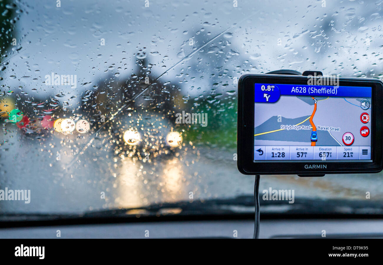 Satnav monitor collegato al finestrino di un'automobile in un giorno di pioggia. Foto Stock