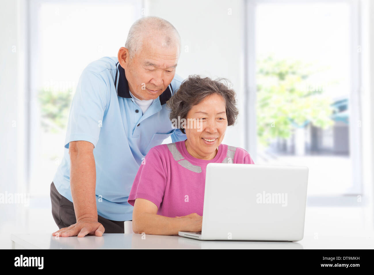 Coppia senior learnin con usando un portatile a casa Foto Stock