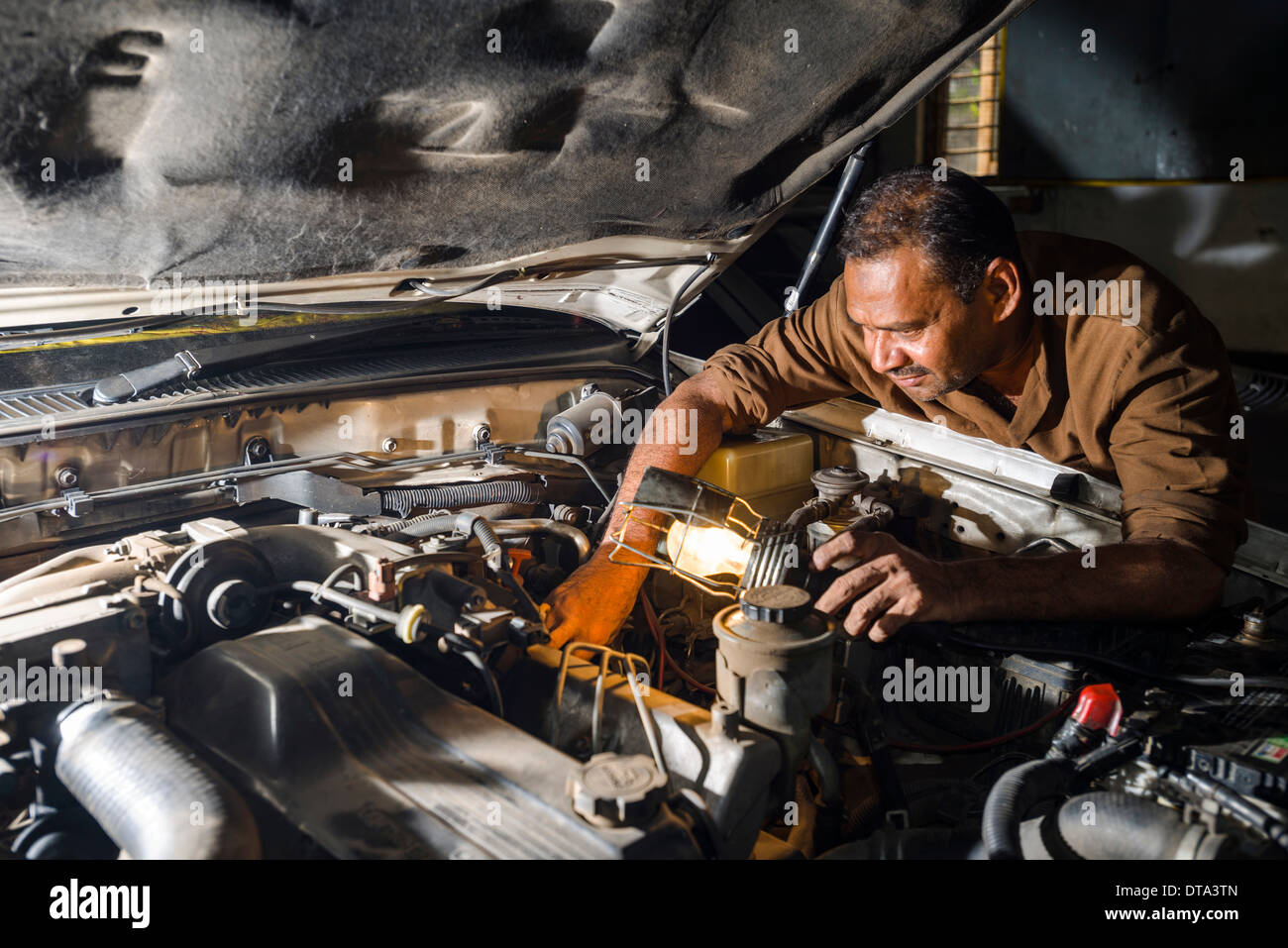 Un meccanico di automobili è la riparazione di una BMW auto in un garage, Fort, Mumbai, Maharashtra, India Foto Stock
