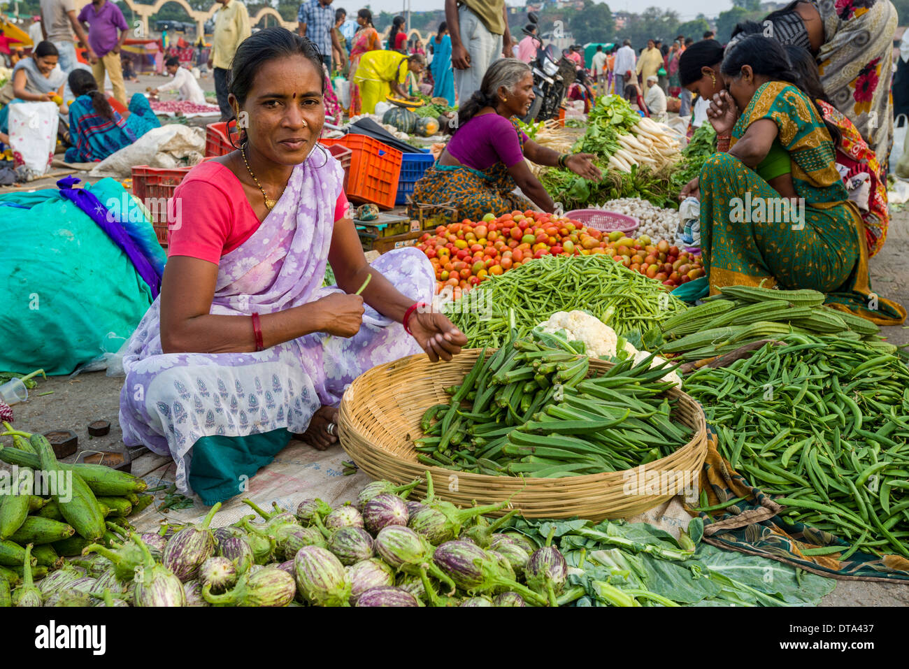 Una donna è la vendita di verdura presso il settimanale mercato ortofrutticolo, Nasik, Maharashtra, India Foto Stock