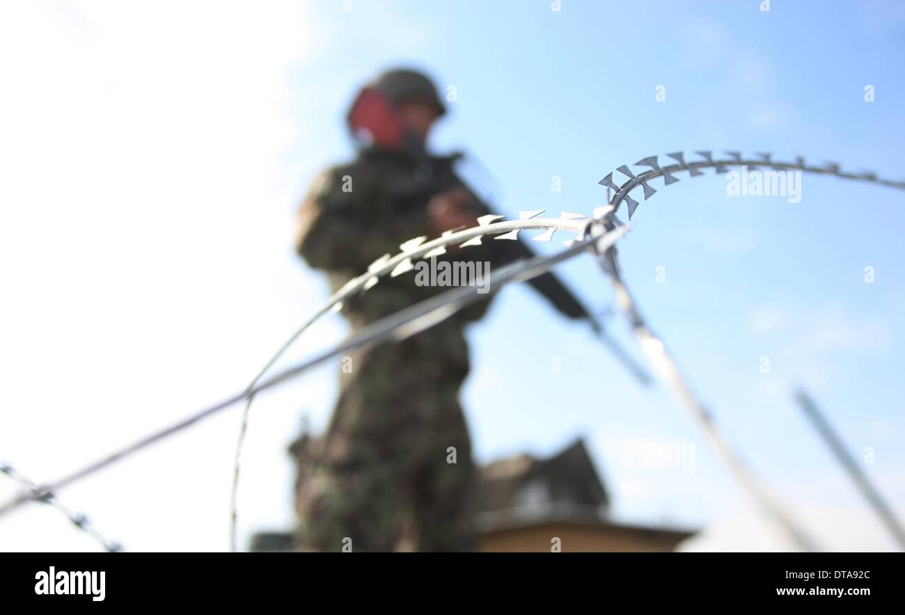 Parwan, Afghanistan. Xiii Febbraio, 2014. Un esercito nazionale afghano soldato sta di guardia al di fuori del Bagram un centro di detenzione nella provincia di Parwan, Afghanistan settentrionale, il 13 febbraio, 2014. Gli Stati Uniti Forces-Afghanistan (USFOR-A) giovedì ha condannato il rilascio dei talebani detenuti dal governo afgano dall'ex U.S.-run Bagram un centro di detenzione in anticipo il giorno. Credito: Ahmad Massoud/Xinhua/Alamy Live News Foto Stock
