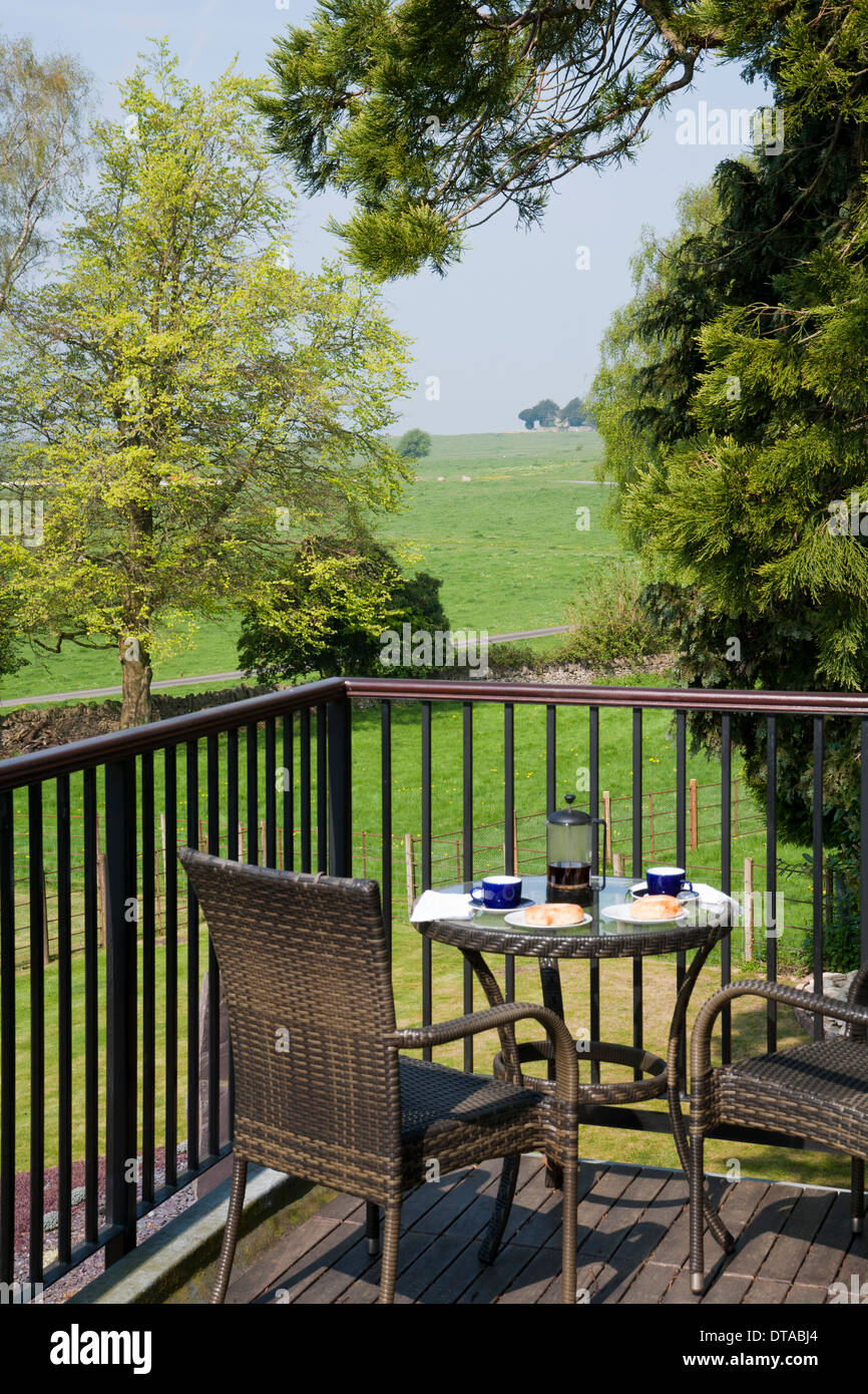 Giardini del Regno Unito. Due persona tavolo e sedie da giardino su un balcone con vista sulla campagna. Foto Stock