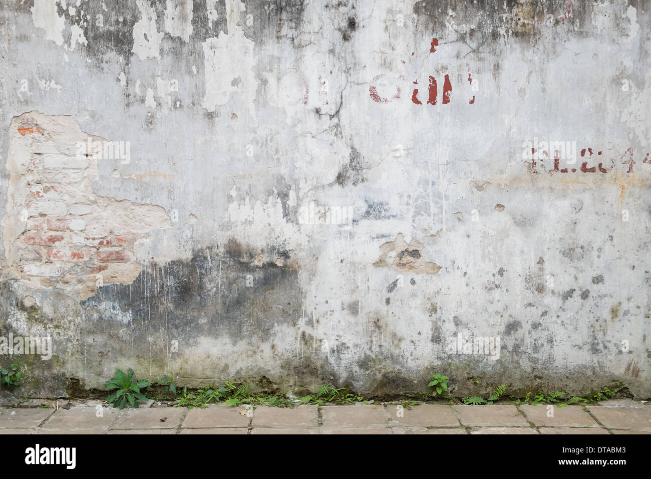 Sullo sfondo di un weathered vecchio muro in mattoni di esposizione Foto Stock
