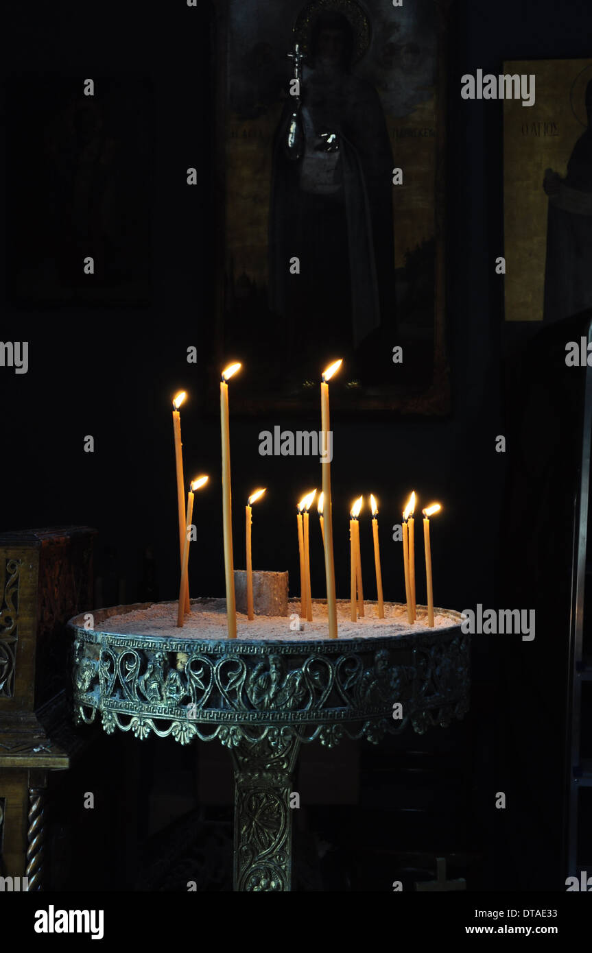 Vintage manouali bizantino candela stand in dark chiesa ortodossa interni. Foto Stock