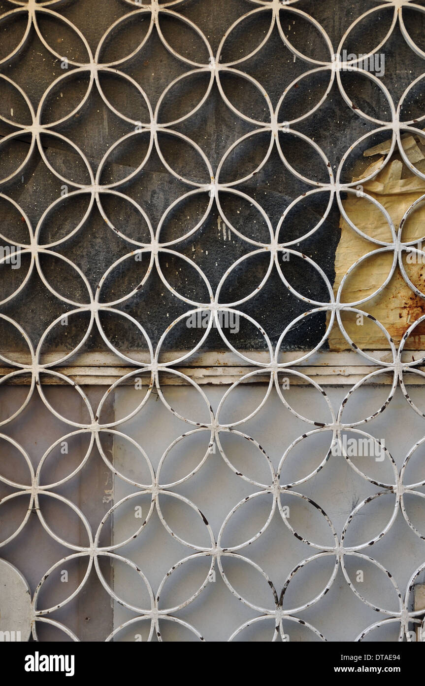 Metallo arrugginito porta con cerchi geometrici motif e vernice in vetro colorato sfondo. Foto Stock