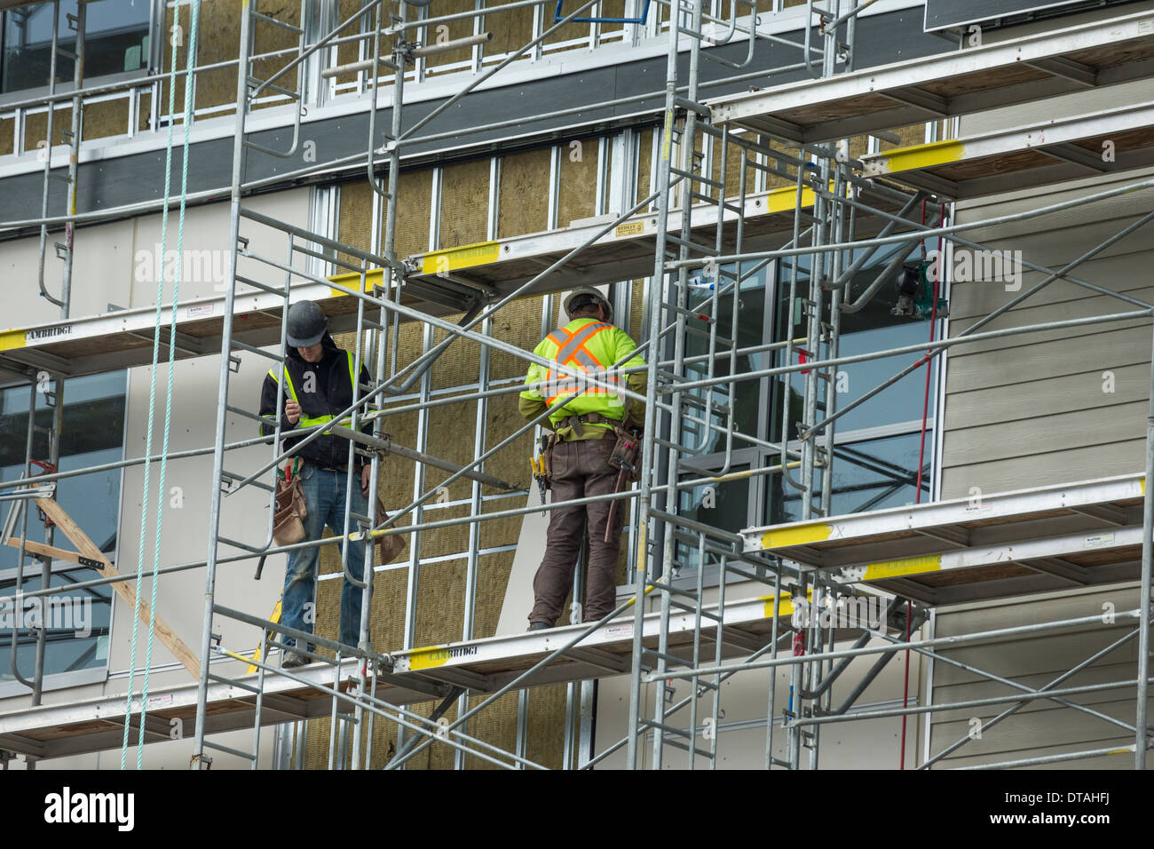 Operai sul ponteggio elevato a costruzione sito-Victoria, British Columbia, Canada. Foto Stock