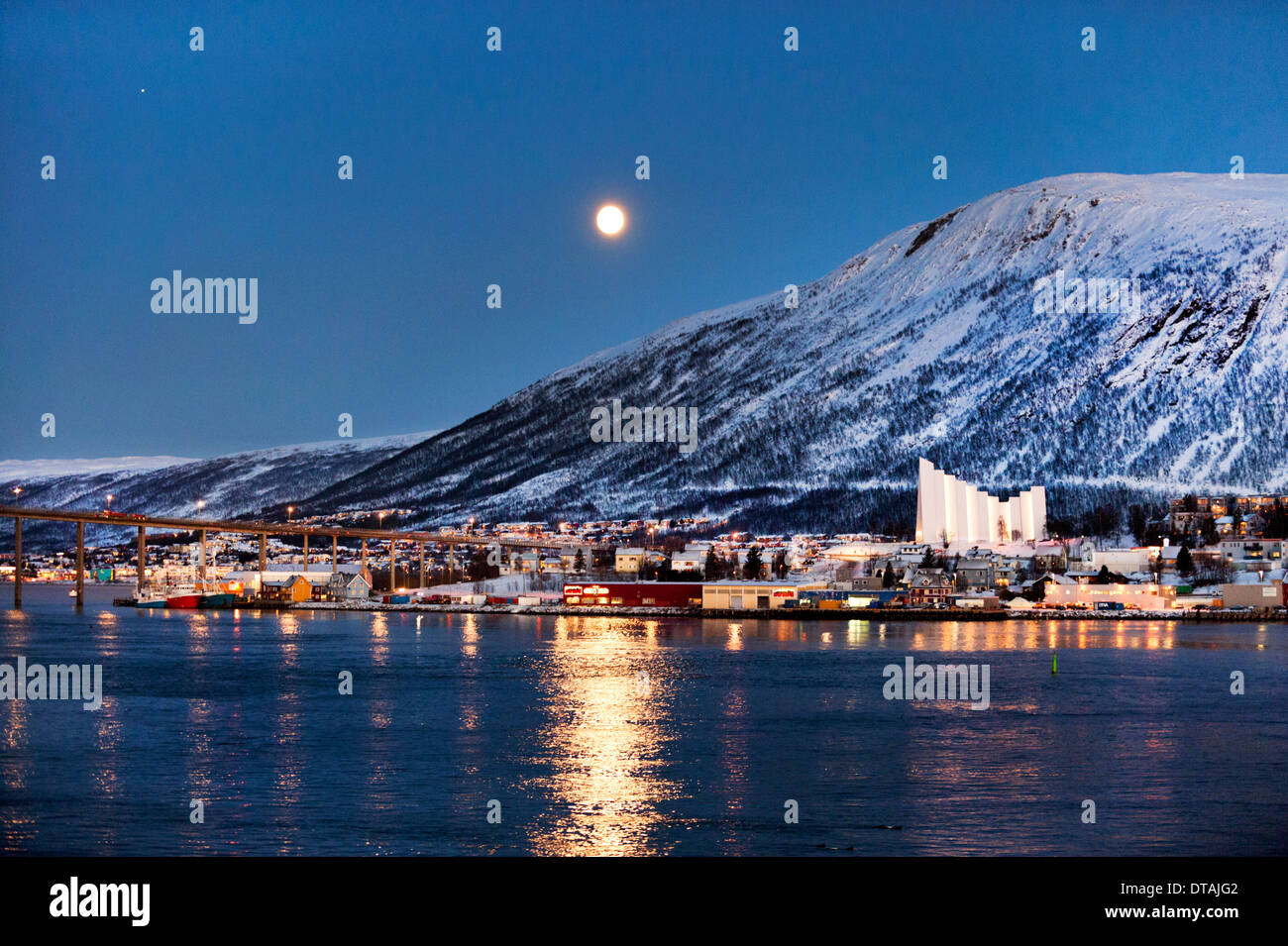 Vista notturna al chiaro di luna della città e porto Tromsø, Troms County, Norvegia, con la Cattedrale dell'Artico e il ponte stradale Foto Stock