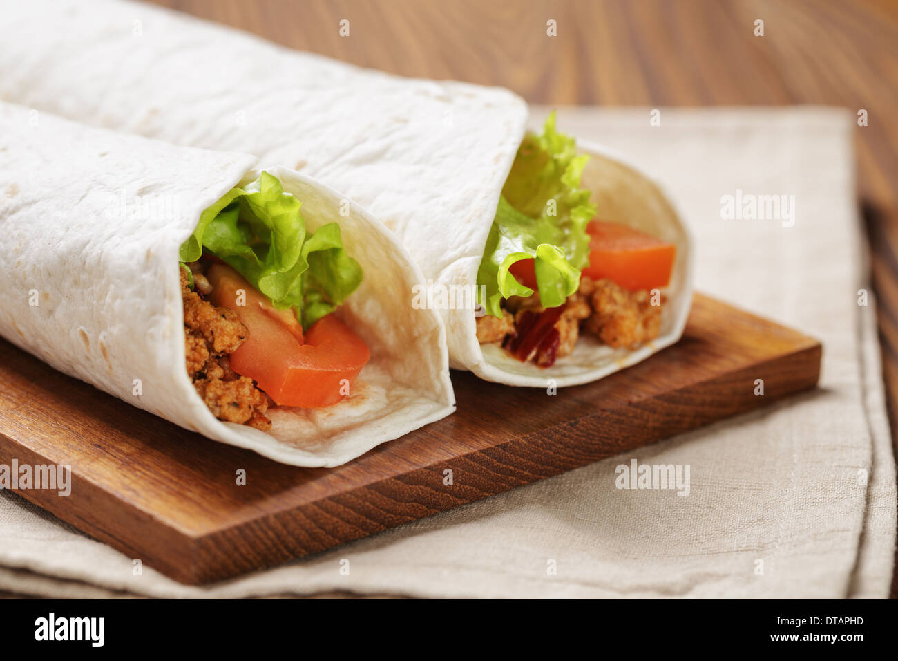 Burrito di manzo con pomodoro e foglia di insalata sul vecchio tavolo in legno in stile rustico Foto Stock