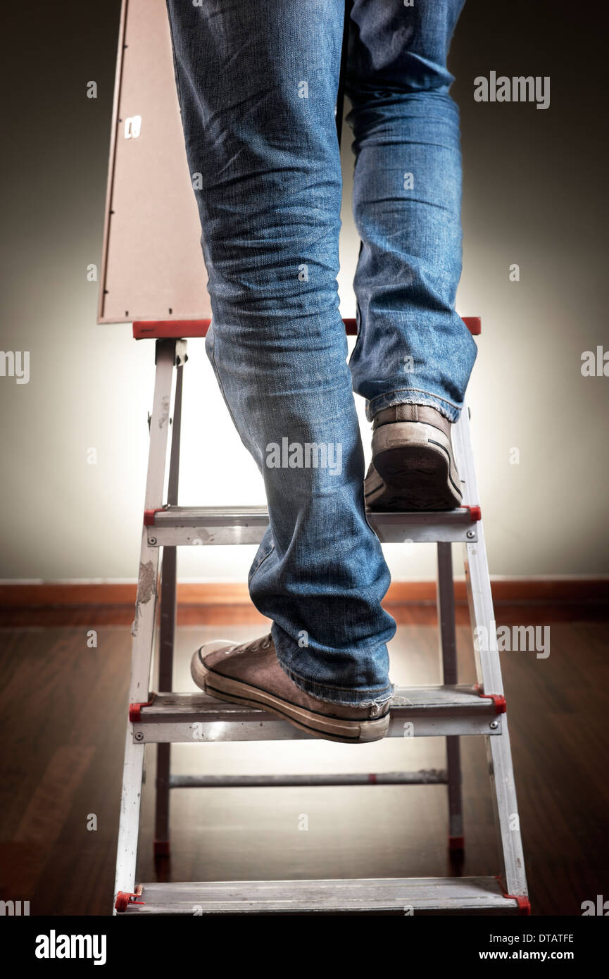 Uomo con Picture Frame durante la salita sulla scala Foto Stock