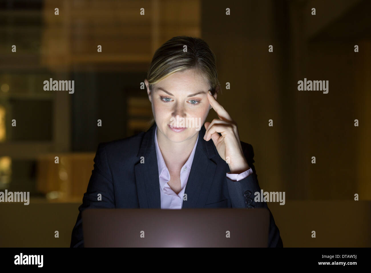 Ritratto di imprenditrice lavora fino a tardi nel suo ufficio su laptop Foto Stock