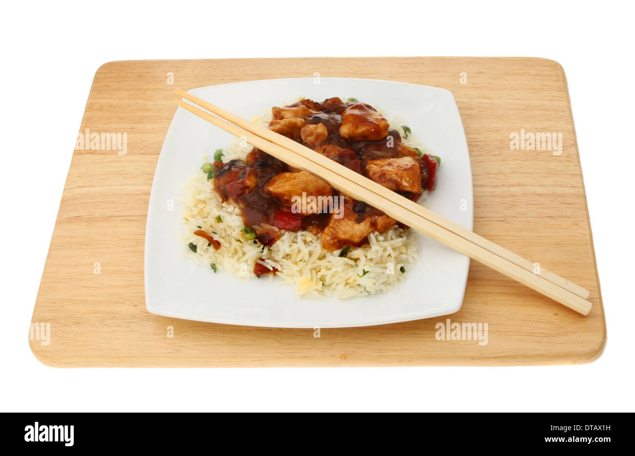 Pasto cinese di pollo e salsa del fagiolo nero con bacchette su una tavola di legno isolata contro bianco Foto Stock