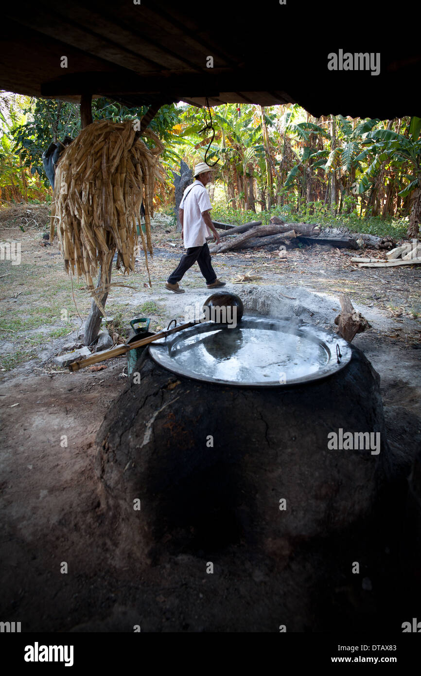 Il contadino panamense sta bollendo il succo di canna da zucchero nella sua piccola fattoria a El Rosario vicino Penonome nella provincia di Cocle, Repubblica di Panama, America Centrale. Foto Stock