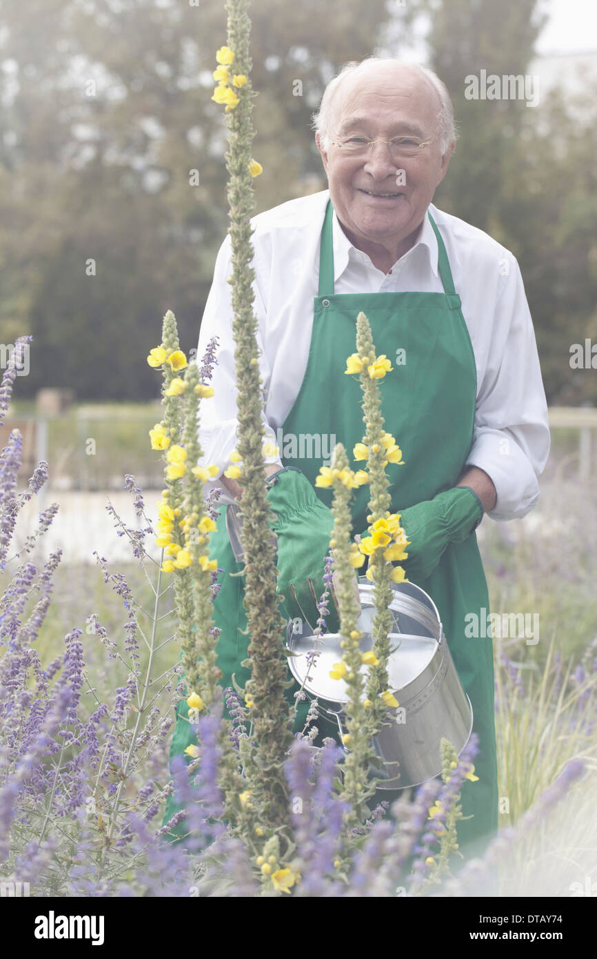 Senior uomo impianto di irrigazione in giardino, ritratto Foto Stock