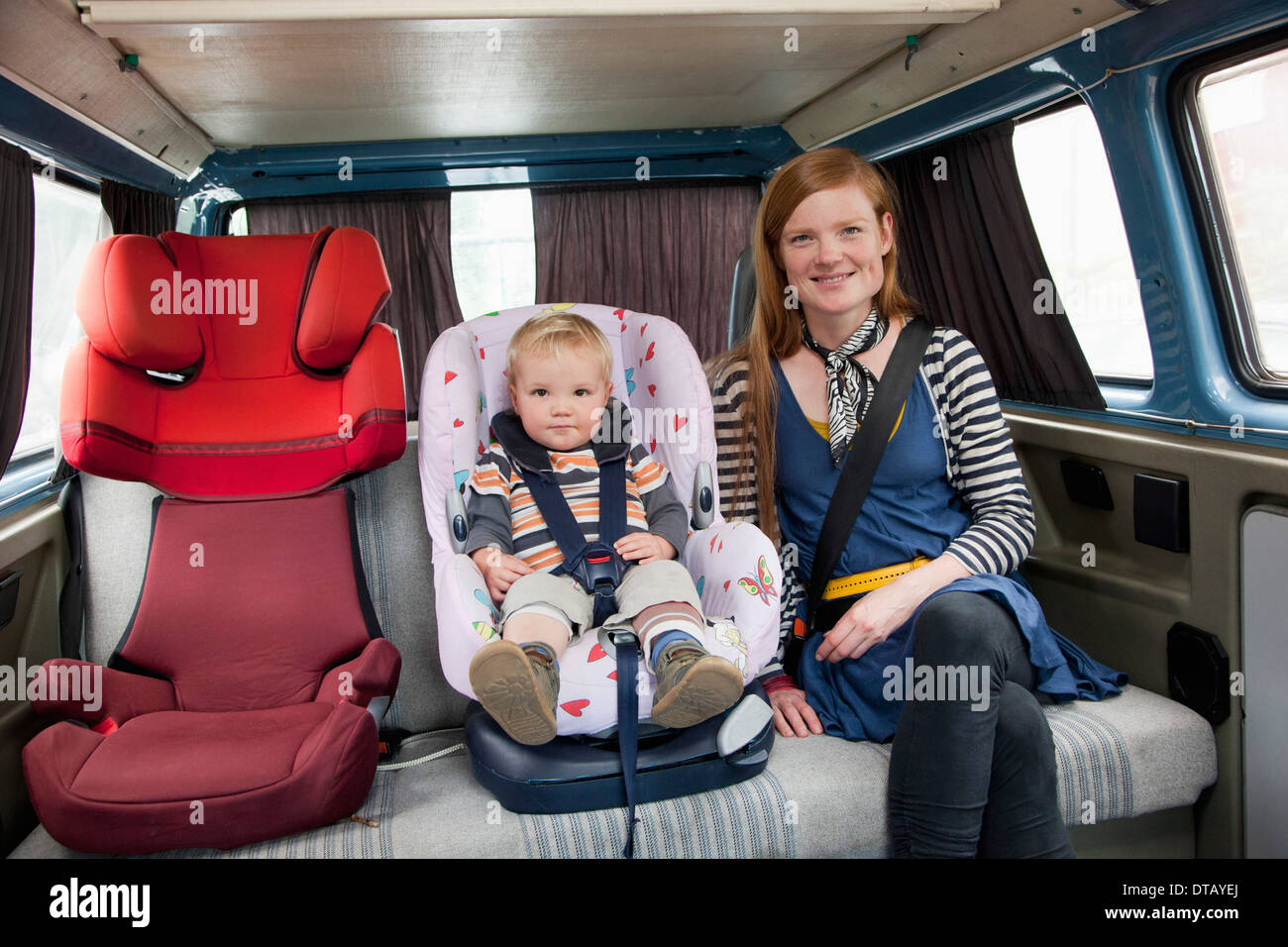 Bambino nel seggiolino per auto con la madre nel sedile posteriore Foto Stock