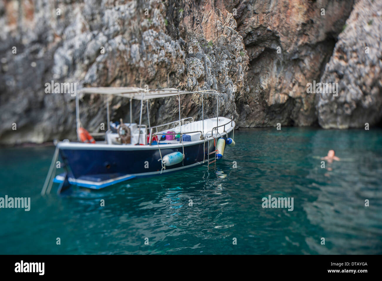 Barca galleggiante sull'acqua dalla formazione di roccia Foto Stock