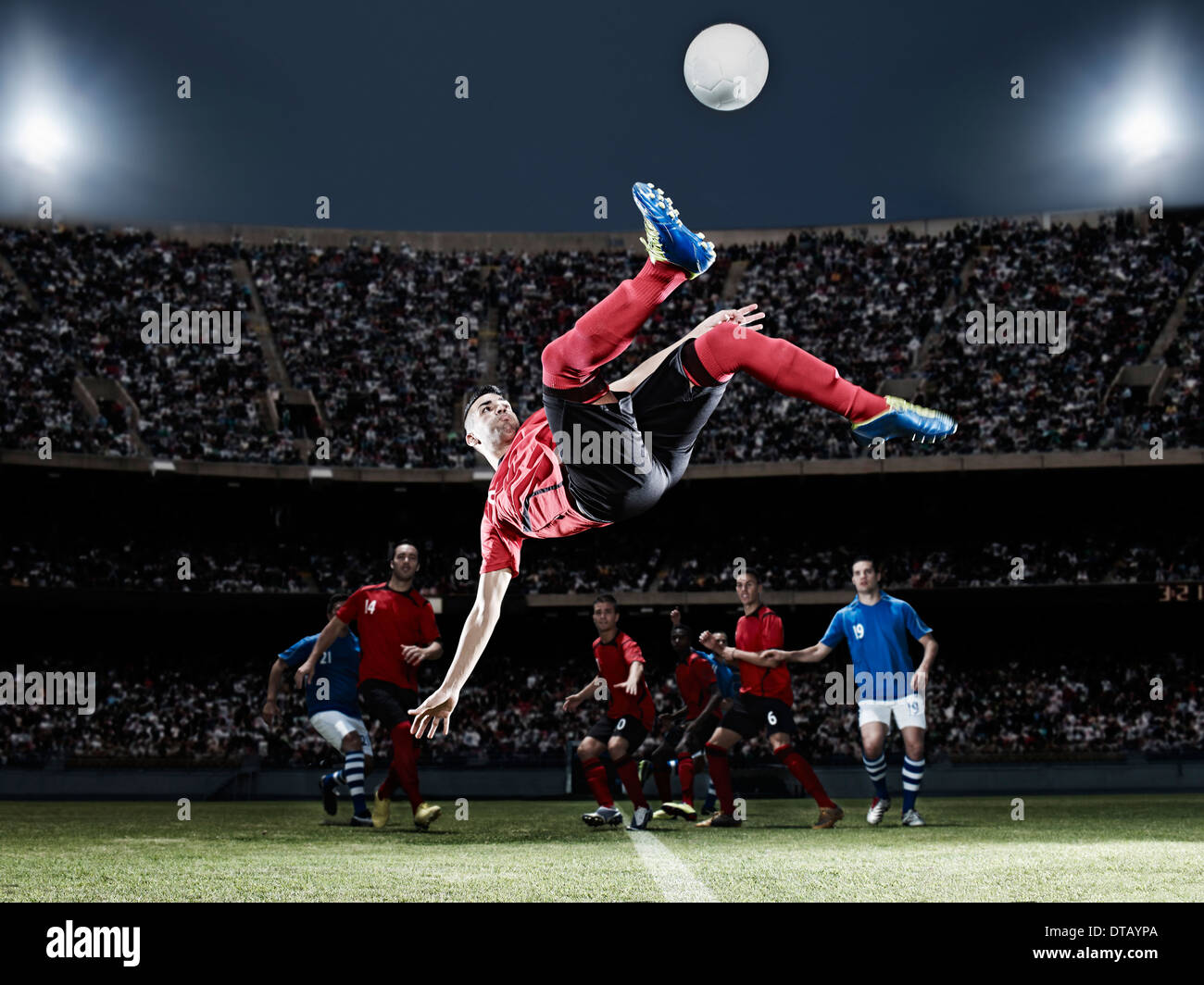 Giocatore di calcio calci palla sul campo Foto Stock Giocatore di calcio calci palla sul campo Foto Stock