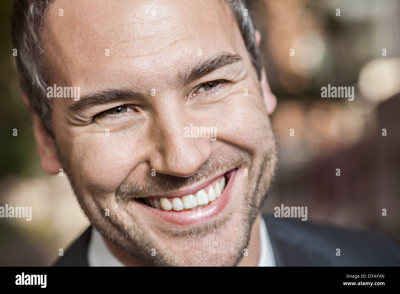 Metà uomo adulto che guarda lontano e sorridente, close-up Foto Stock