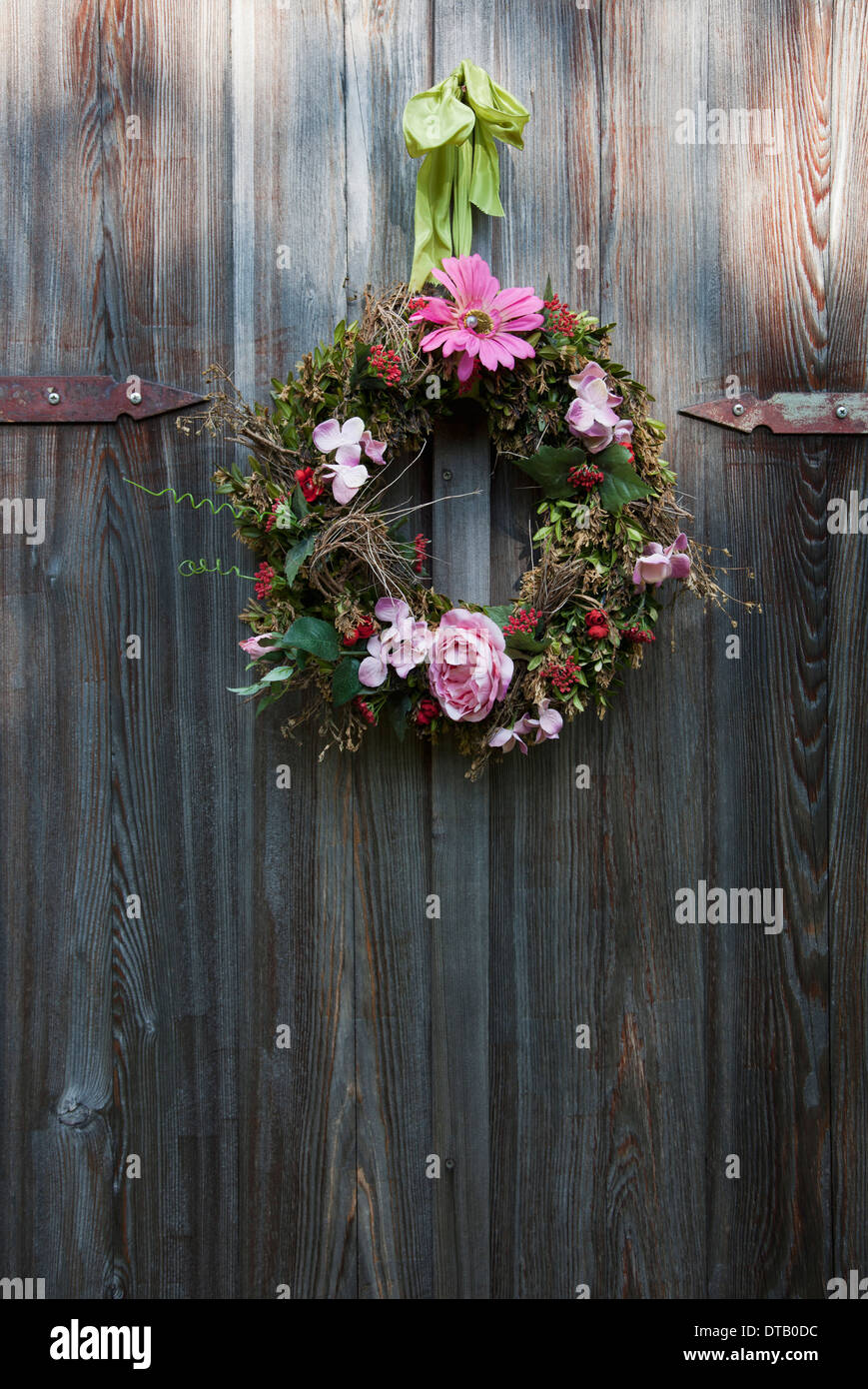 Ghirlanda di fiori appeso sulla porta di legno Foto Stock